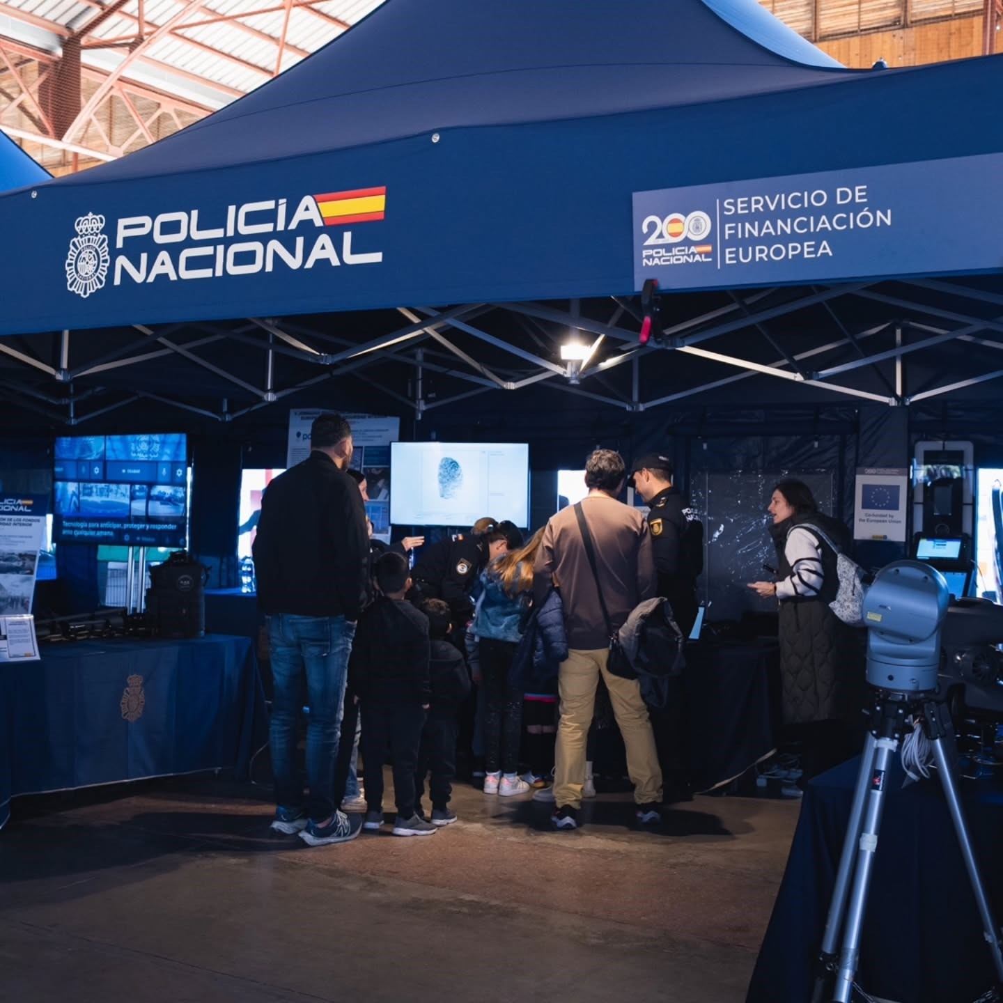 Stand de la Policía Nacional en el que se ve algunos visitantes informándose.